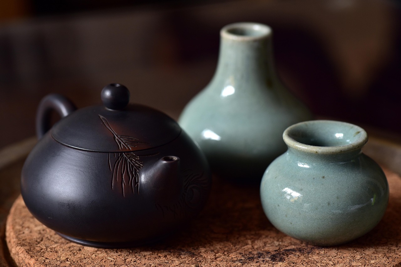Porcelain potteries placed on a table A porcelain teapot and two decorative pieces placed on a table
